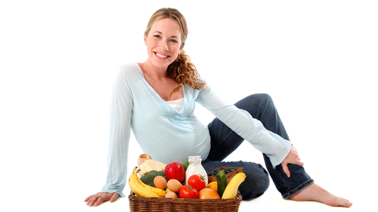 Беременная женщина сидит с овощами