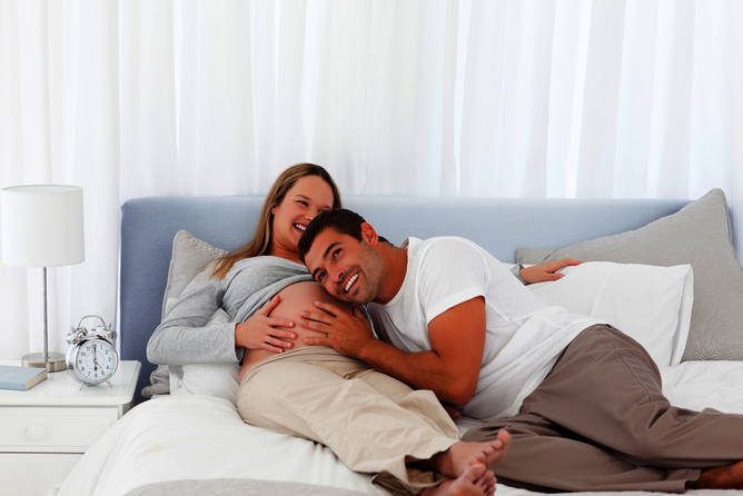 беременная женщина с мужчиной на кровати