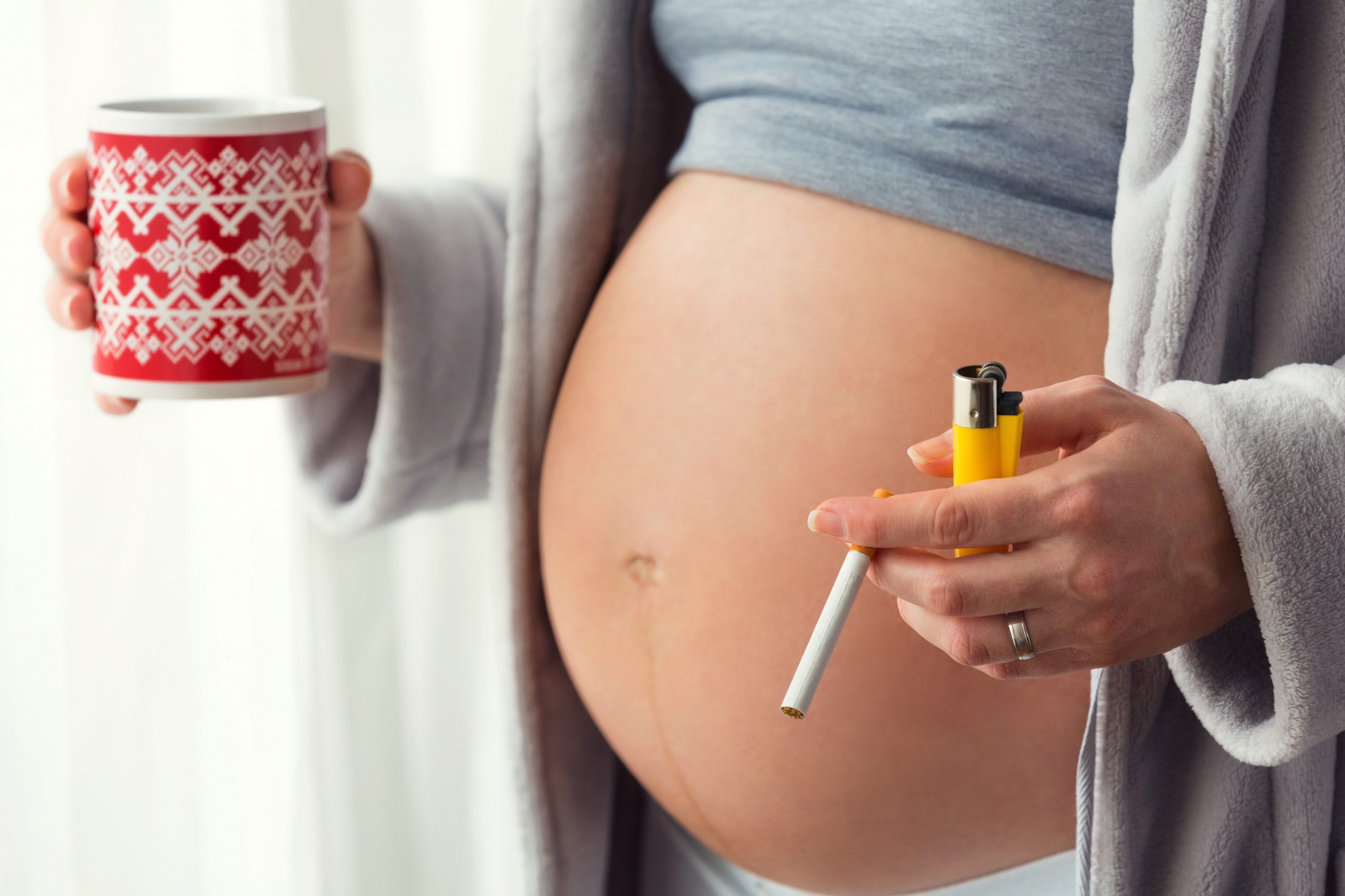 беременная держит сигарету