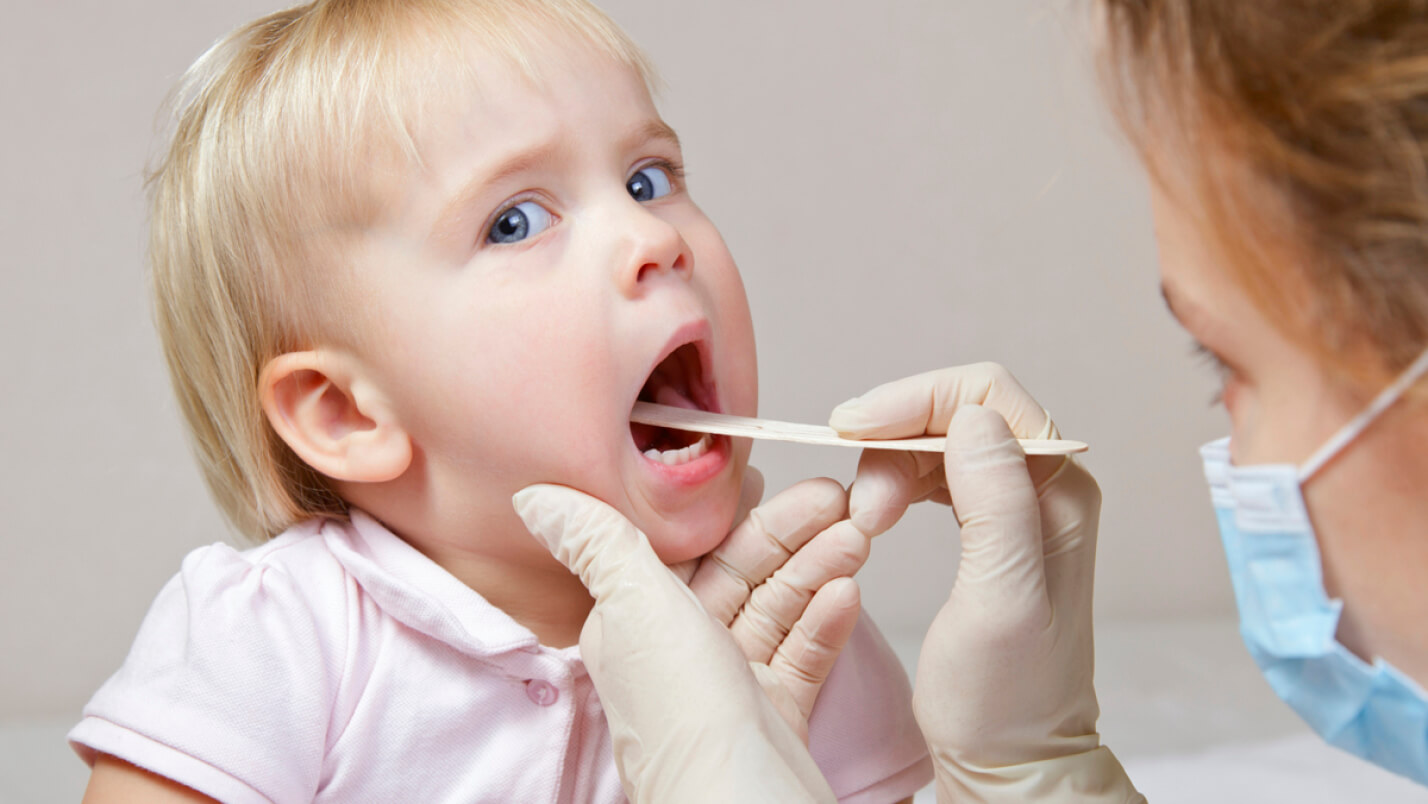 врач осматривает горло у ребенка